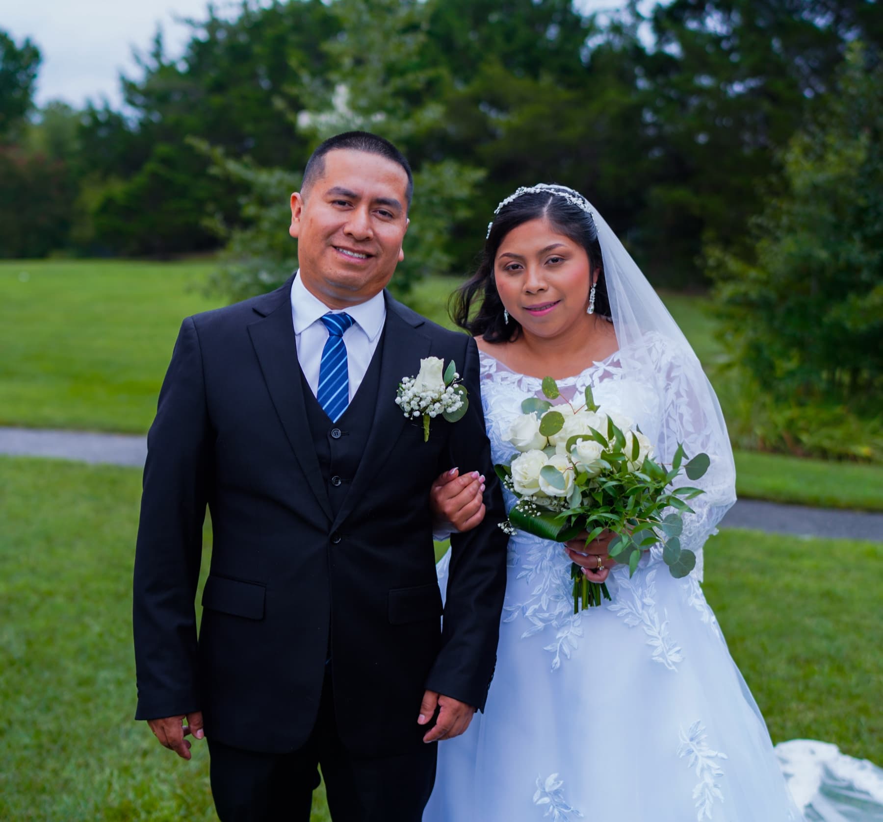 Newly married couple standing together during an outdoor wedding portrait